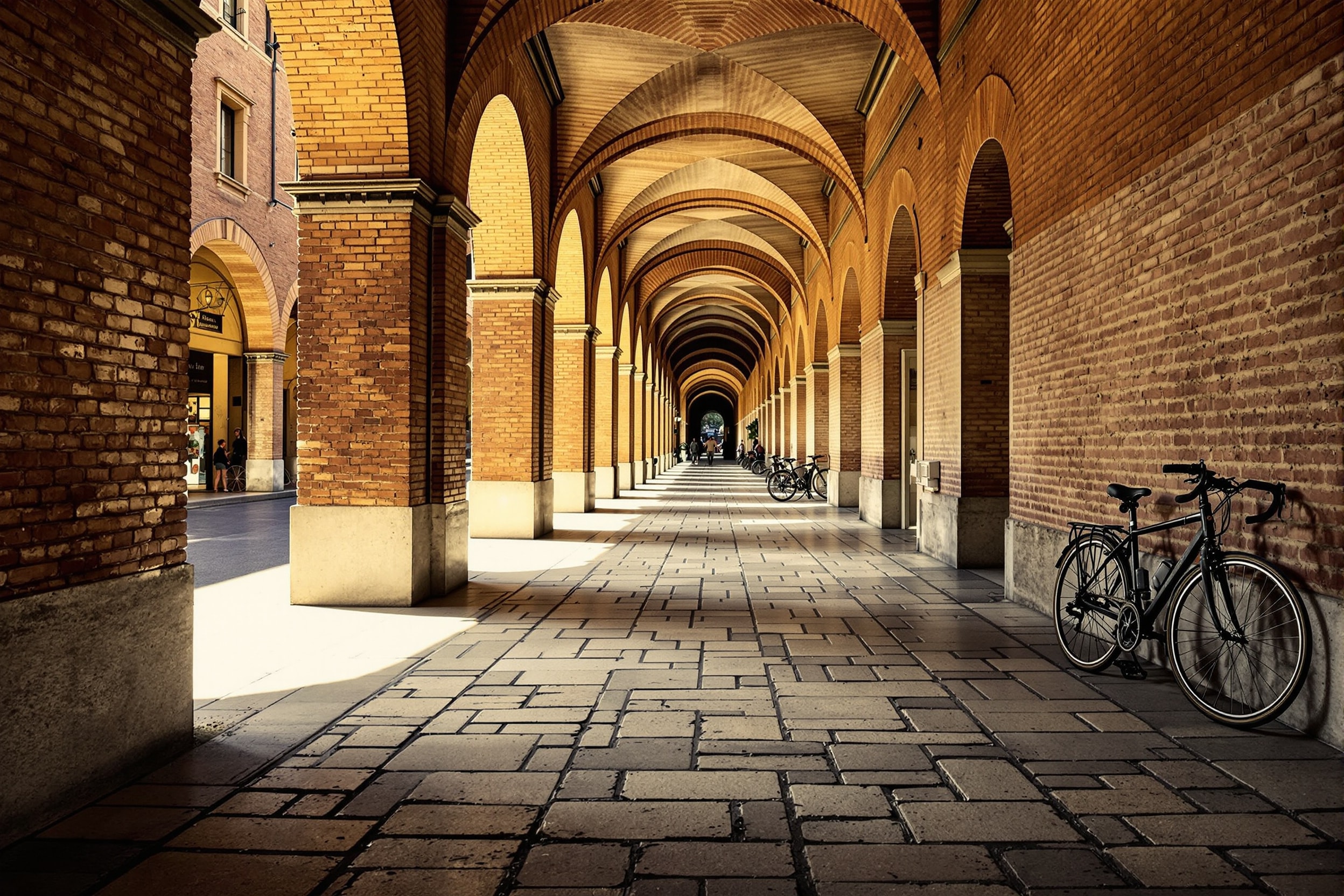Portico medievale in mattoni con pavimentazione in trachite e luce radente del mattino